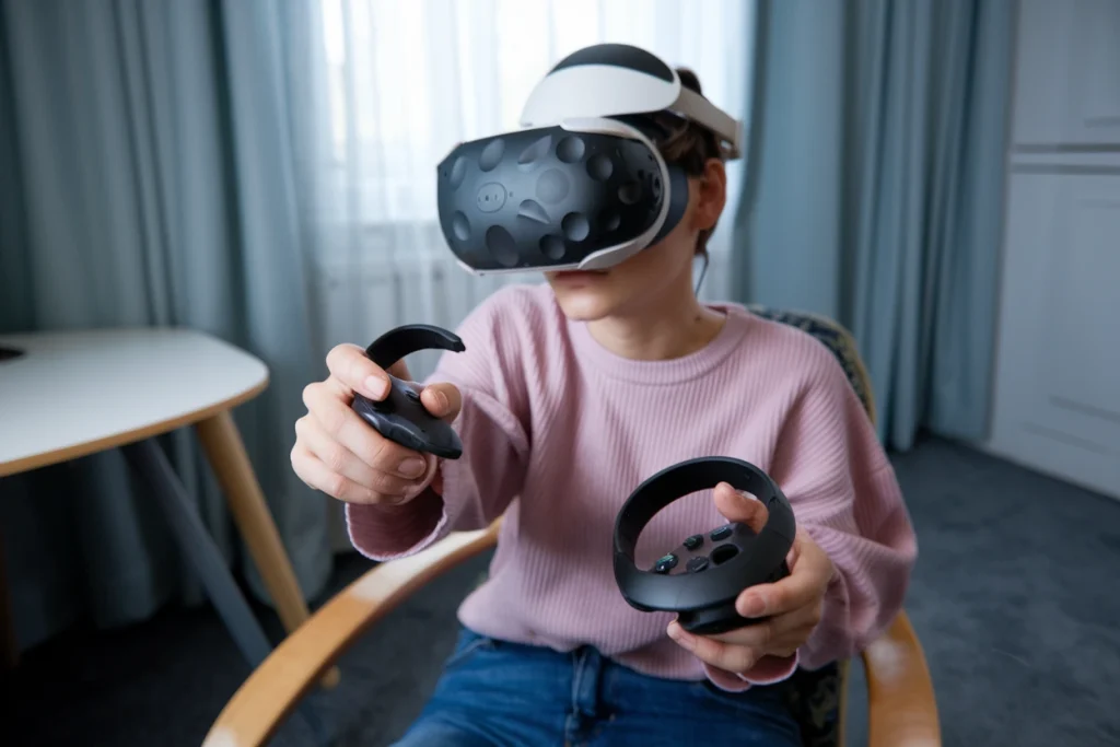 A photo of a person wearing a VR headset and holding a broken video game controller.